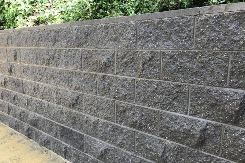 A beautifully designed retaining wall in a landscaped garden.