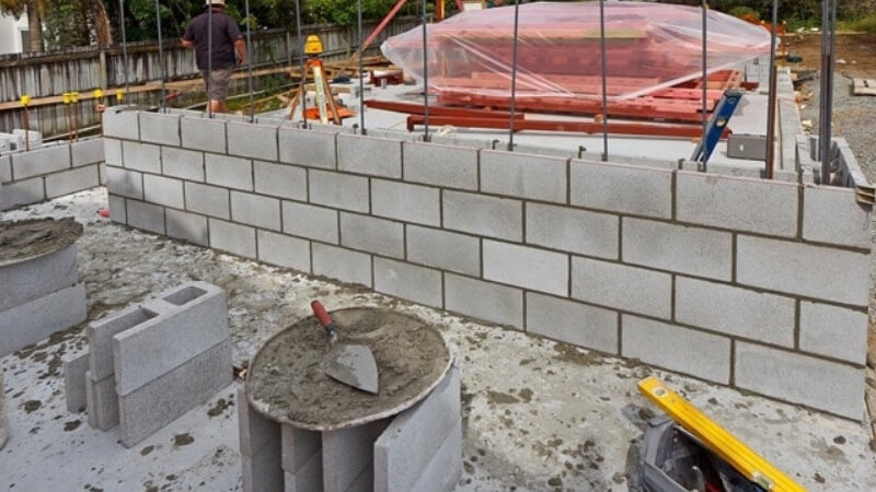 A concrete block retaining wall under construction.