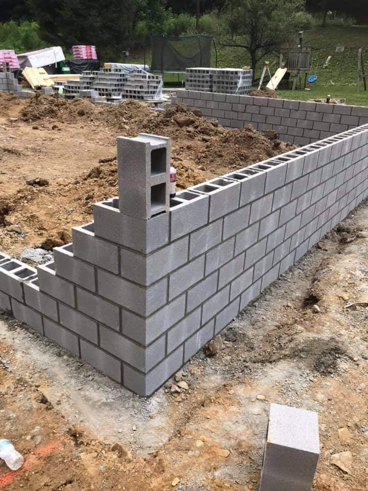  Site preparation for retaining wall construction with workers using machinery