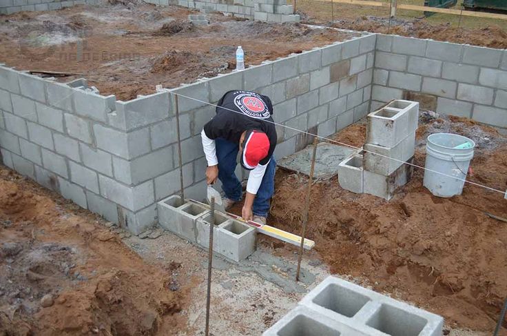 A contractor building a sturdy block wall.