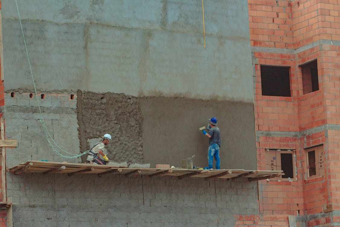 A team of masonry professionals performing maintenance on a stone wall